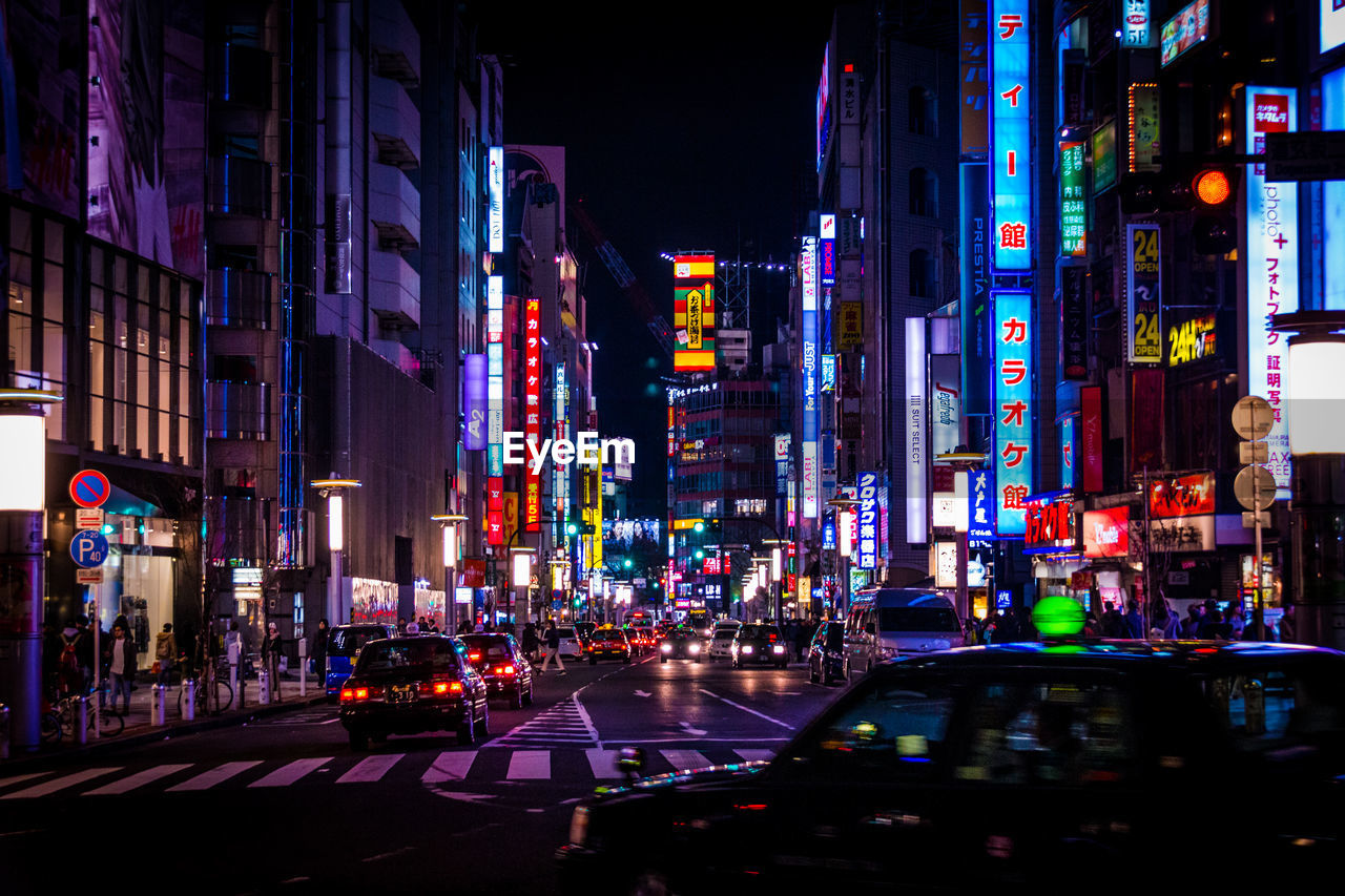 Cars moving on road in illuminated city at night