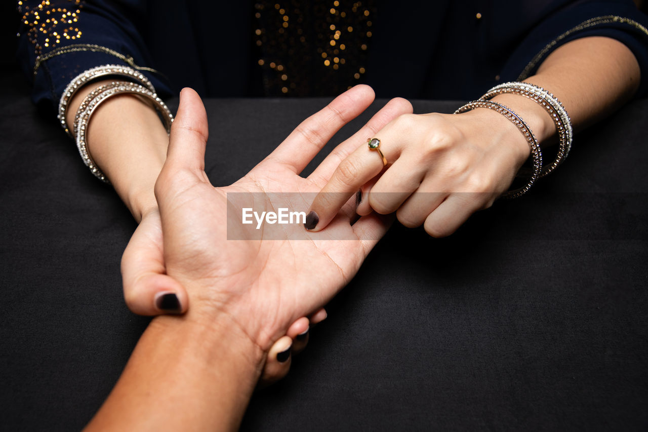 Fortune teller reading fortune lines on hand, top view - palmistry concept.