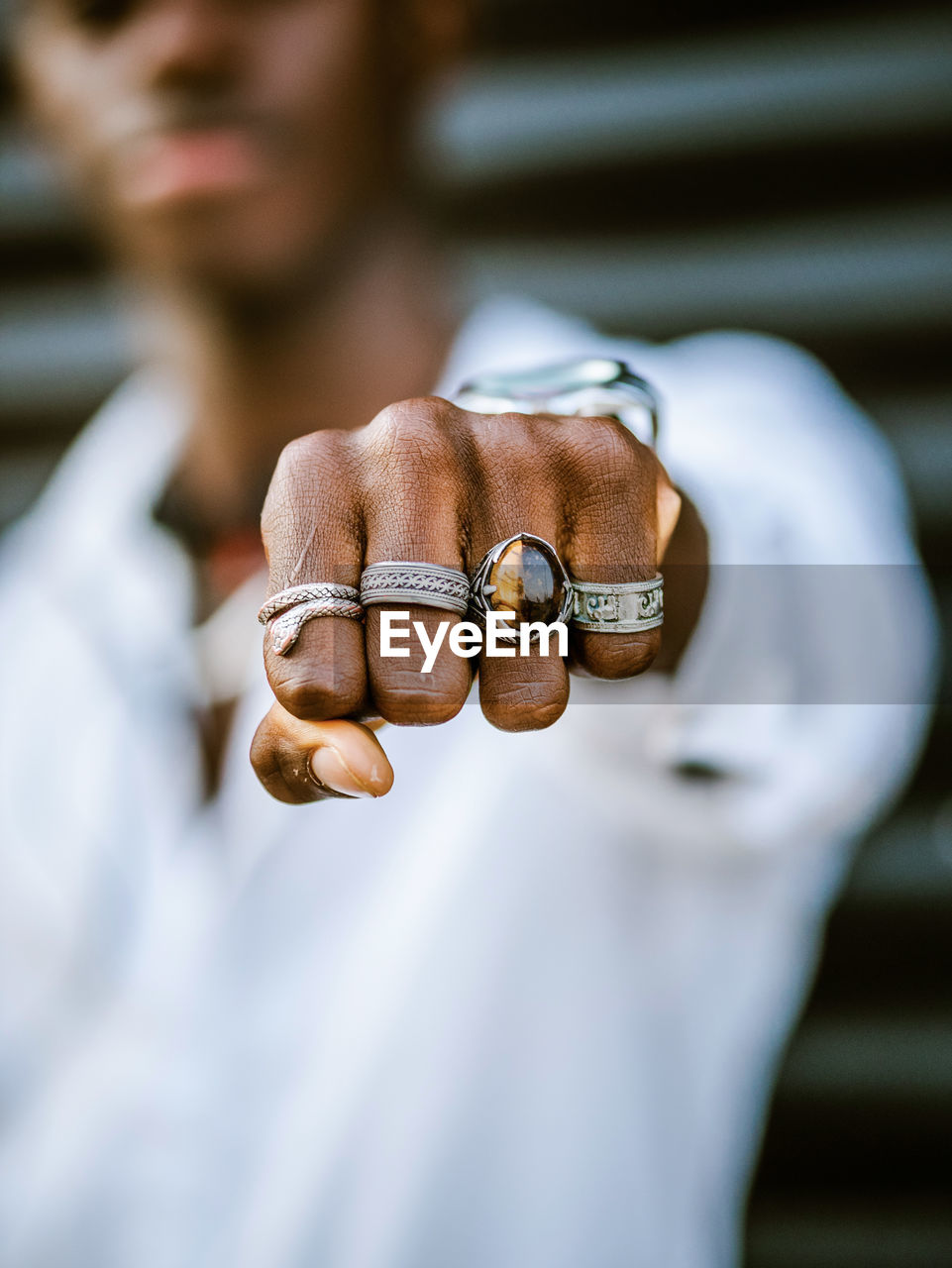 Blurred anonymous african american stylish male showing fist with various trendy silver rings