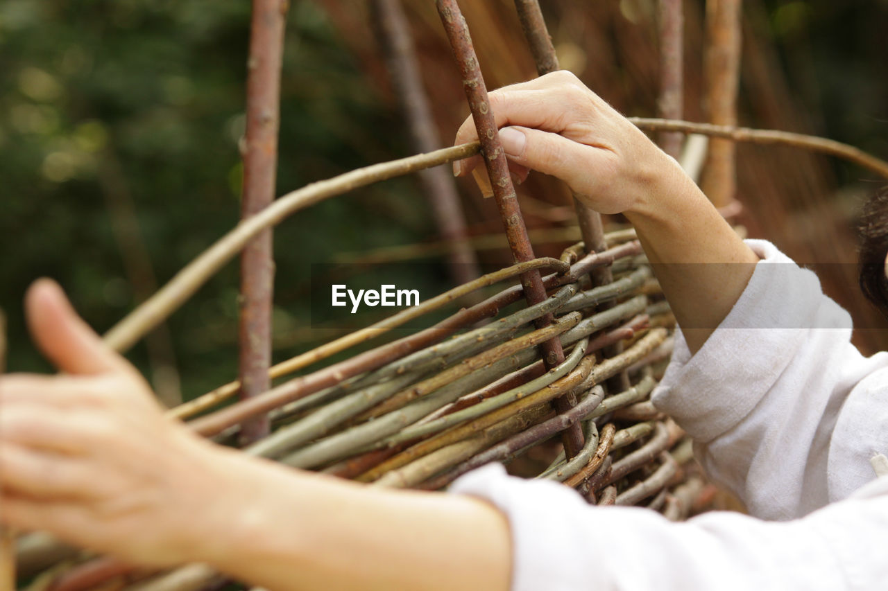 Cropped hands making wicker basket