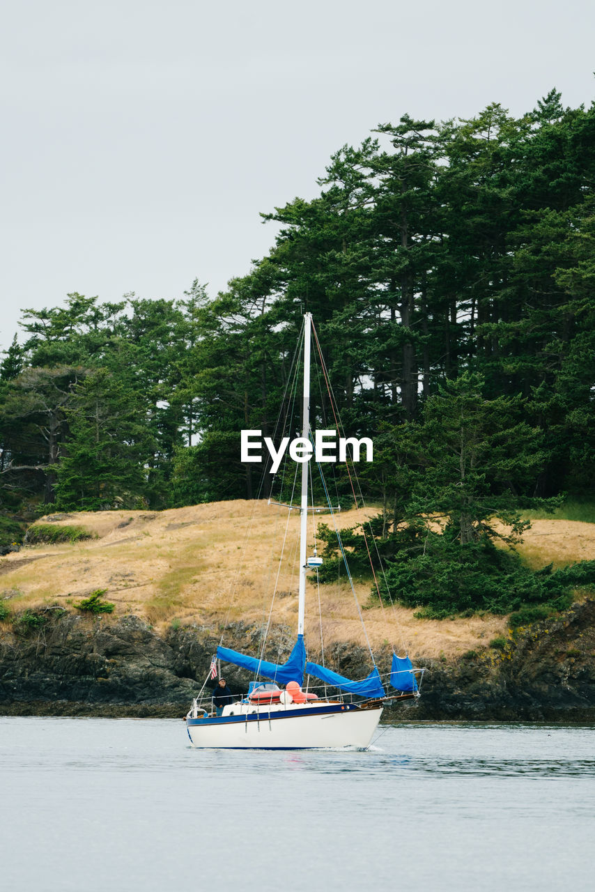 A sailboat motoring through the current at deception pass