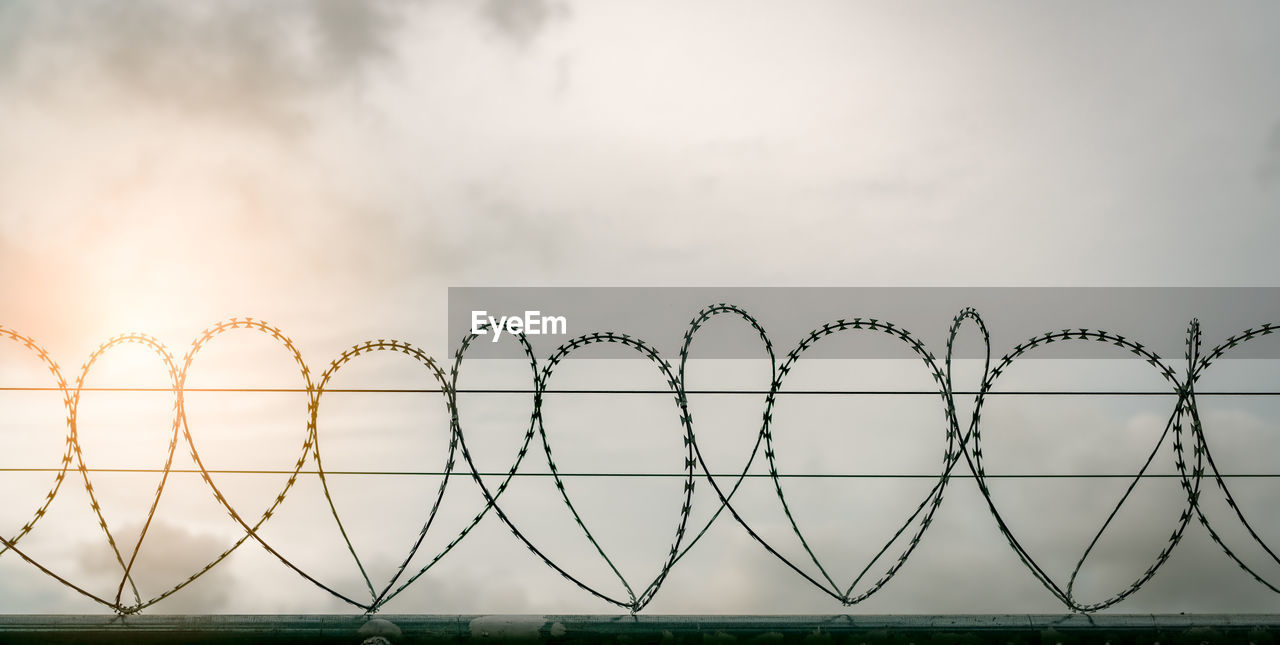 Fence against sky during sunset