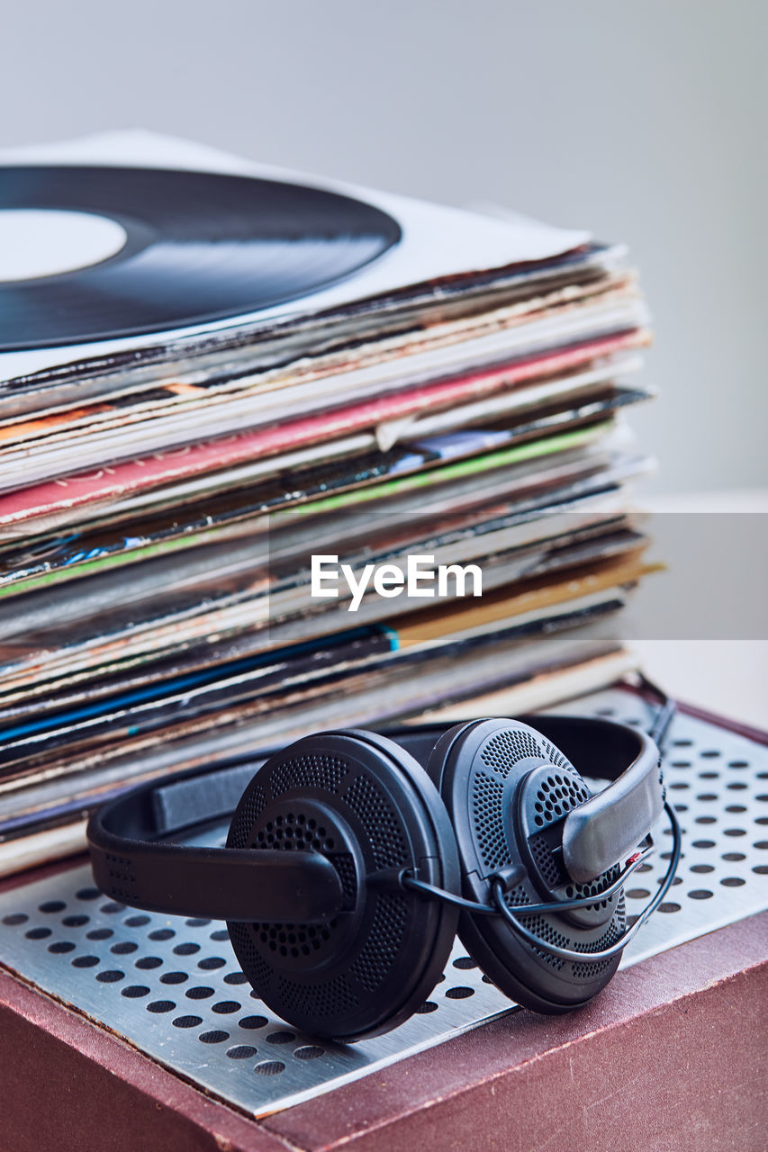 High angle view of records with headphones on table against gray background