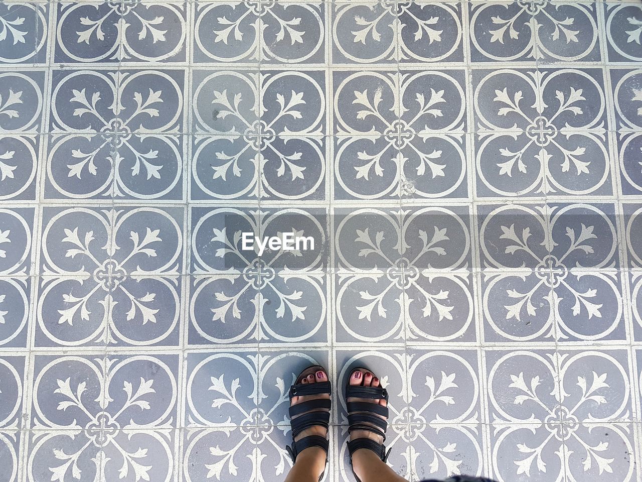 Low section of woman standing on tiled floor