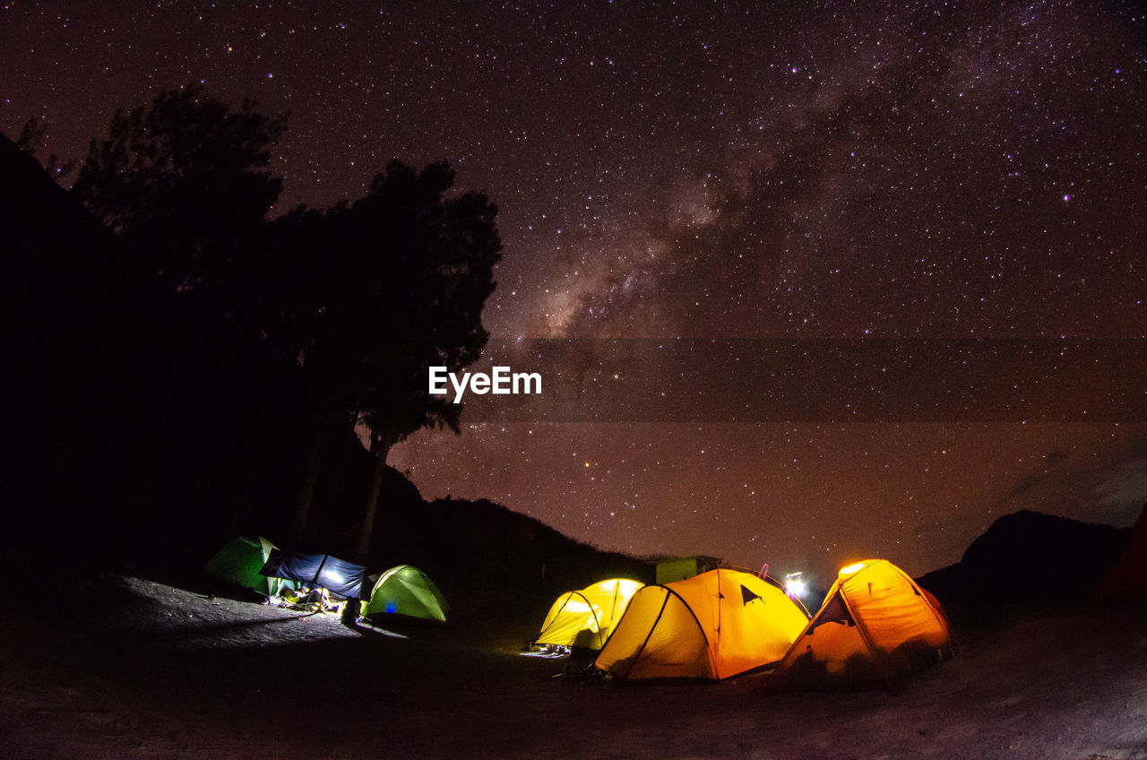 Illuminated tent against sky at night