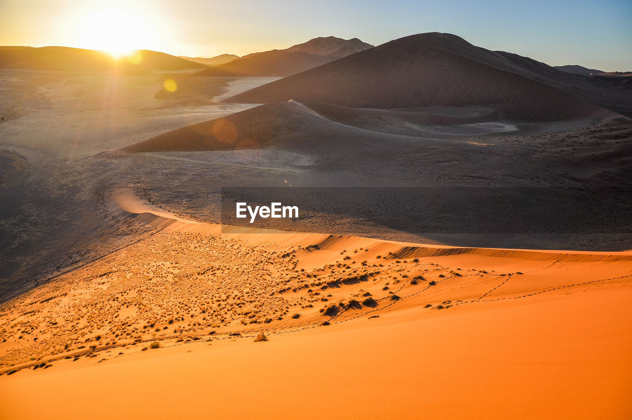 Scenic view of desert against sky during sunset