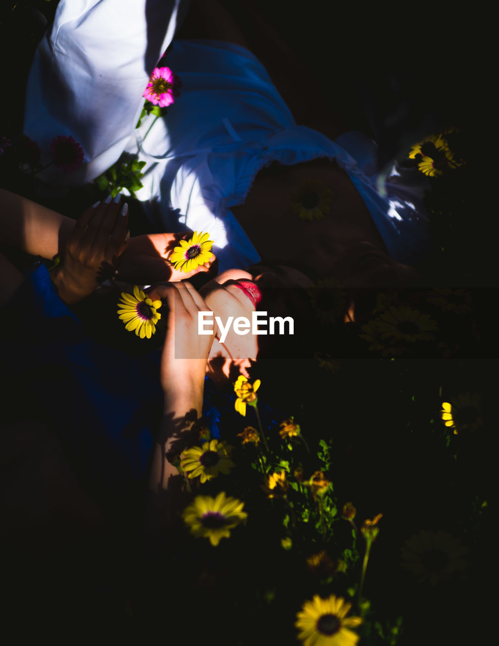 LOW ANGLE VIEW OF WOMAN STANDING ON YELLOW FLOWER