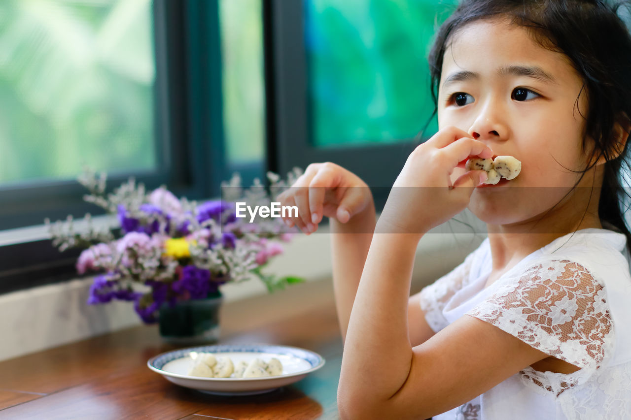 Cute girl eating food at home