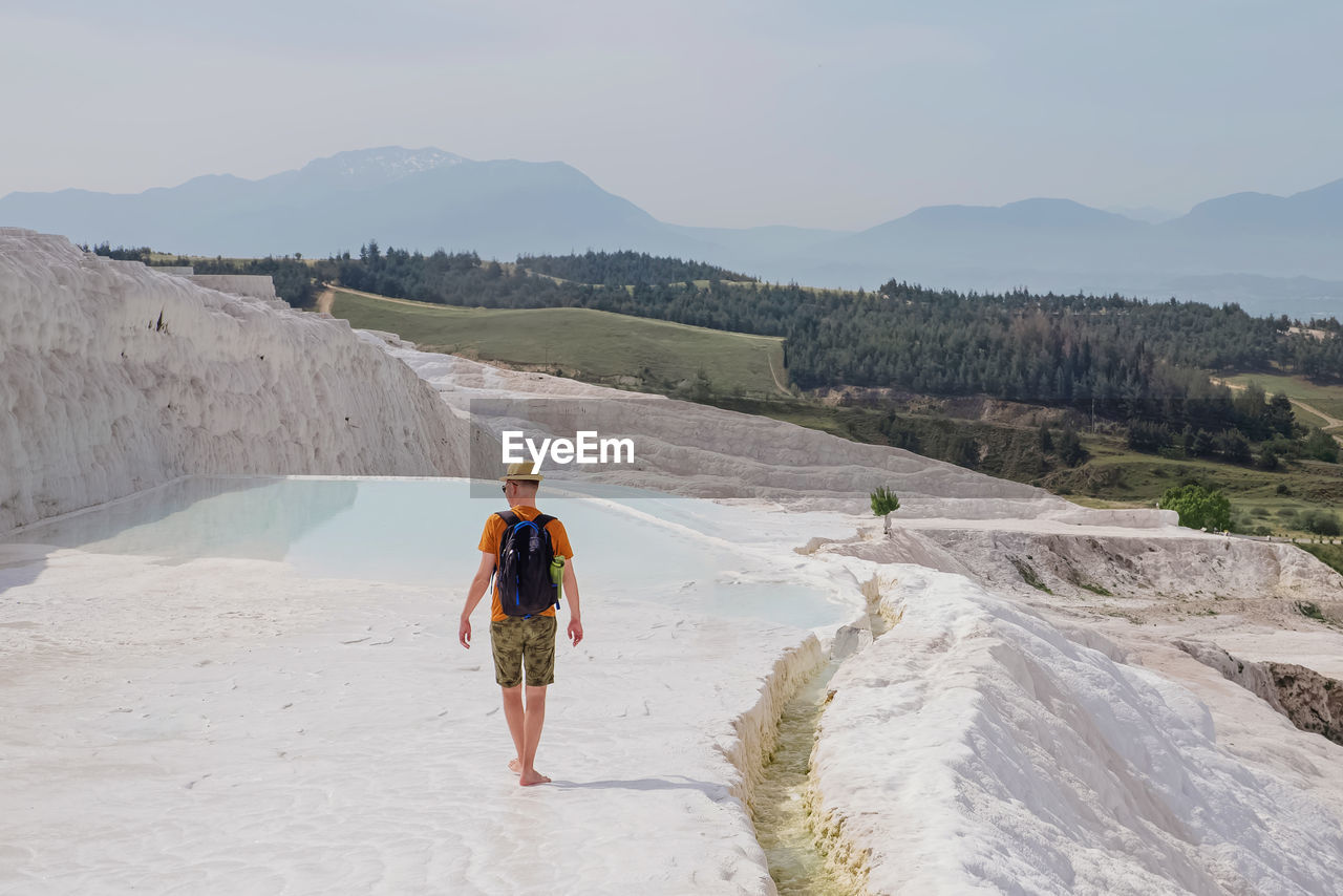 Man walking in famous touristic location, exploring travertine pools at pamukkale, turkey