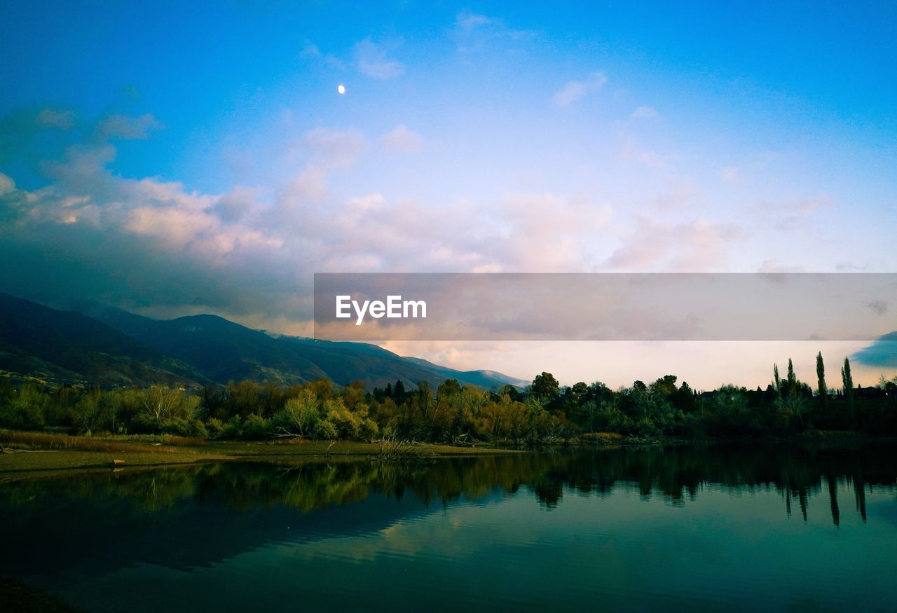 Scenic view of lake and mountains against sky