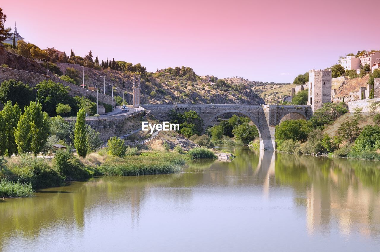 ARCH BRIDGE OVER LAKE AGAINST SKY