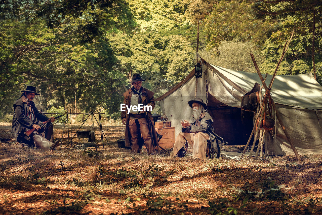 GROUP OF PEOPLE SITTING IN TENT