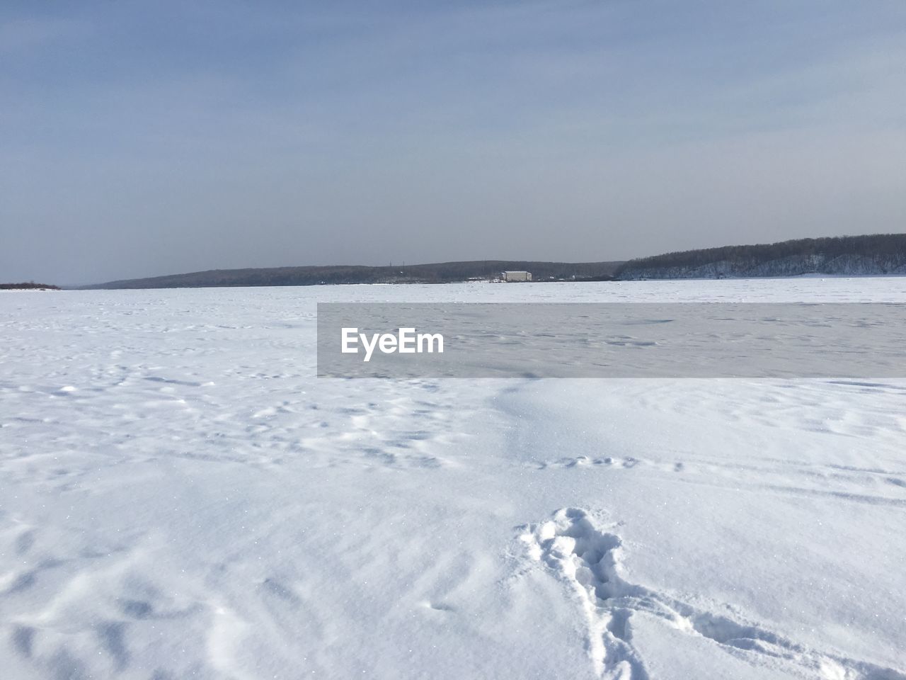 Scenic view of snow covered land against sky