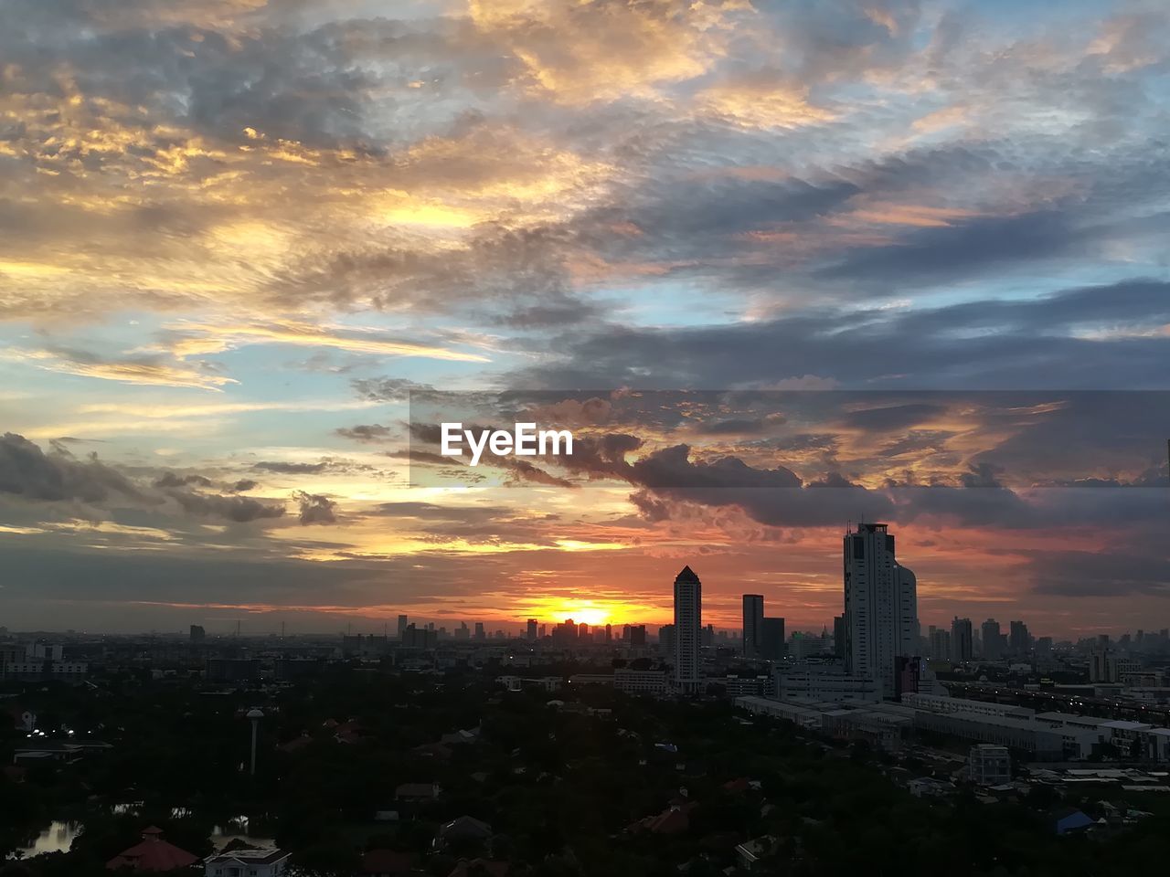 View of cityscape against cloudy sky during sunset