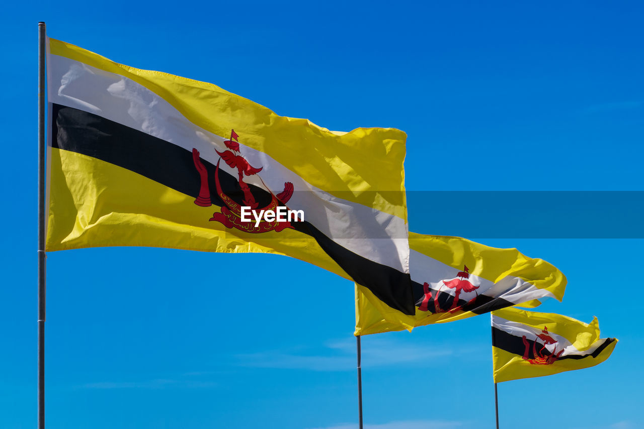 Three flags poles of brunei darussalam on sky background