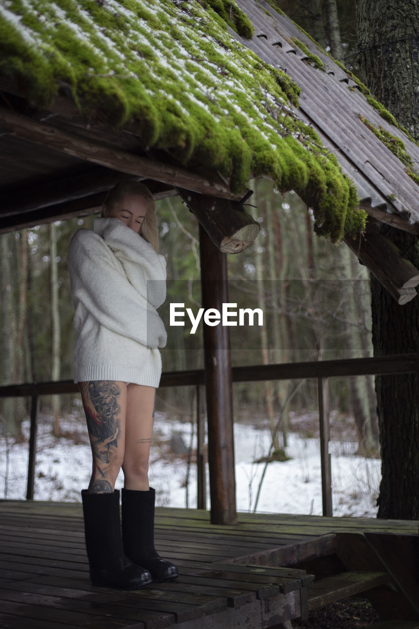 Rear view of woman standing against trees