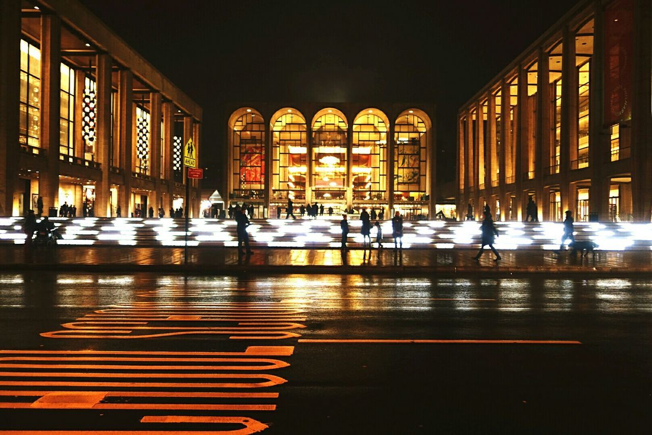 People at illuminated lincoln center at night