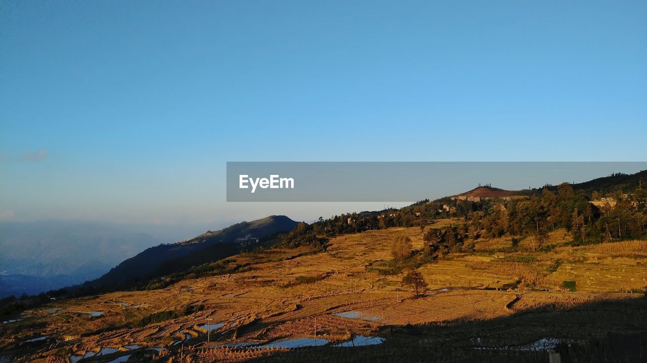 Scenic view of mountains against clear blue sky