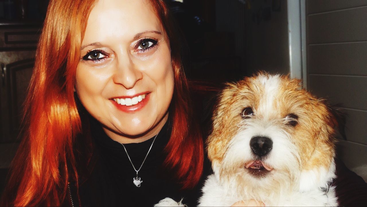 PORTRAIT OF YOUNG WOMAN WITH DOG IN BACKGROUND