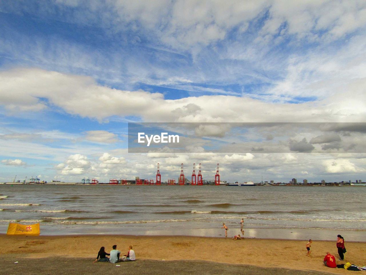 PEOPLE ON BEACH AGAINST SKY