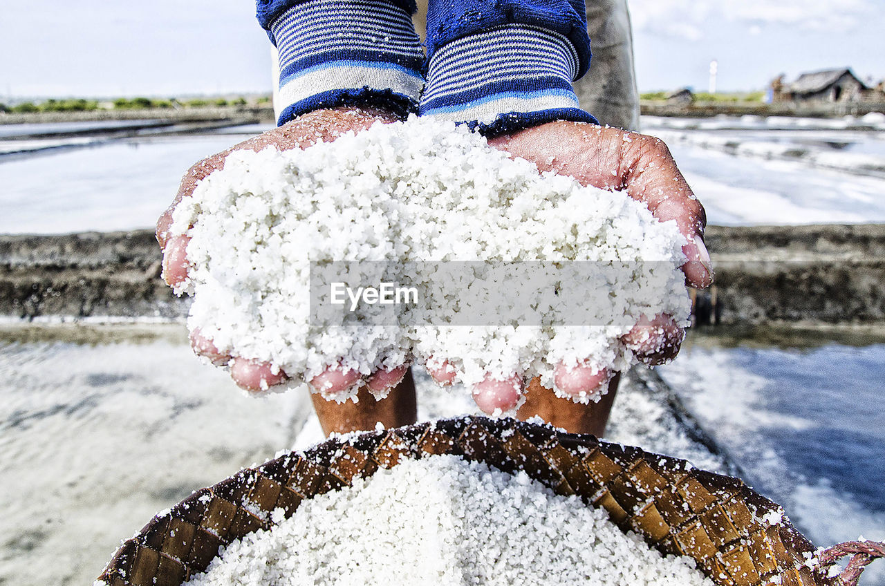 Farmers holding salt when producing salt traditionally in indonesia