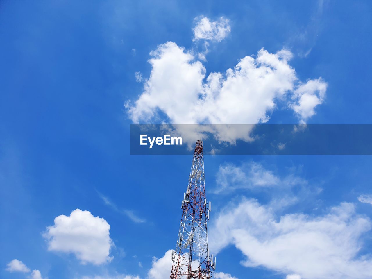 Low angle view of communications tower against blue sky