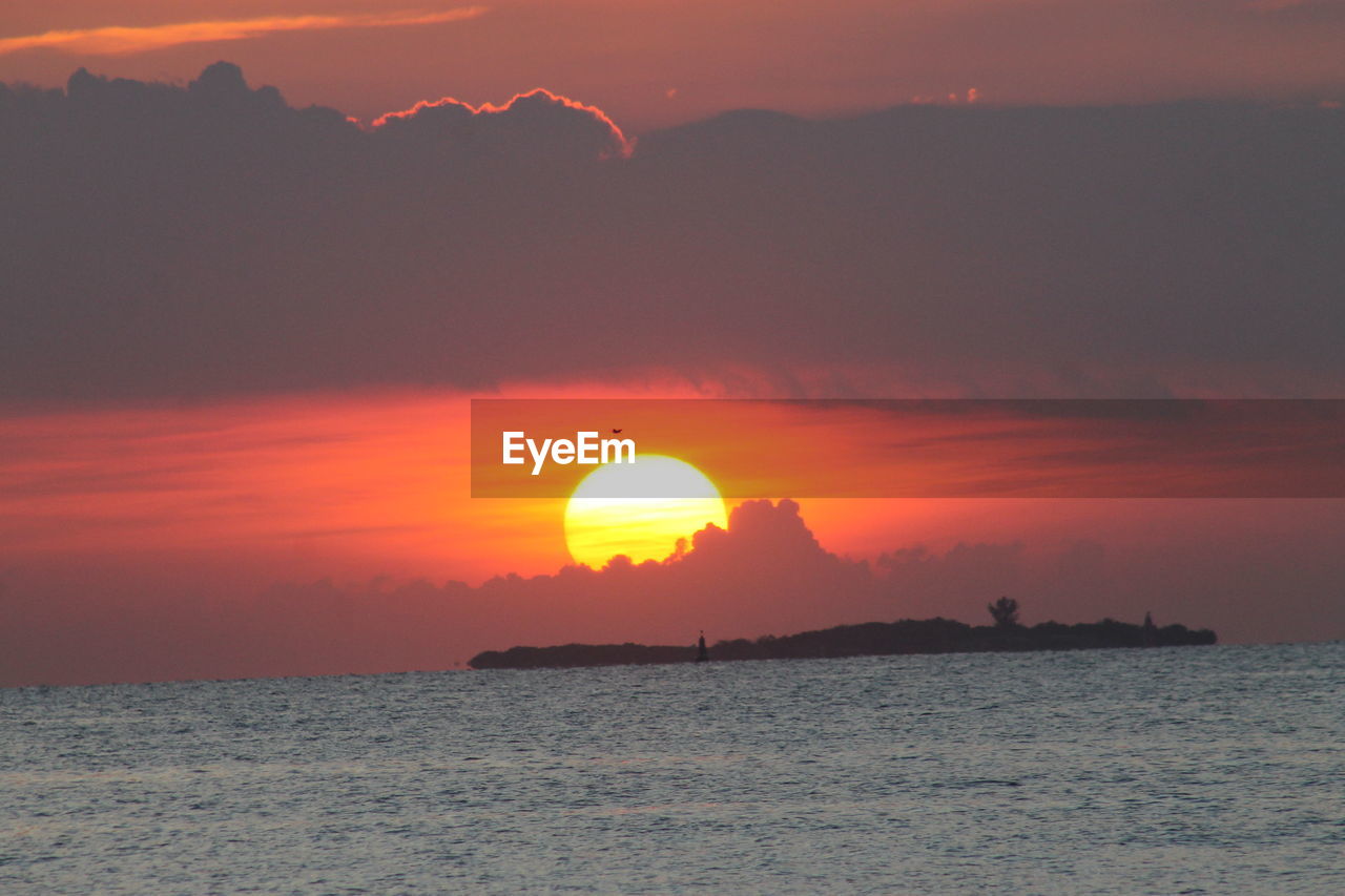 Scenic view of sea against orange sky