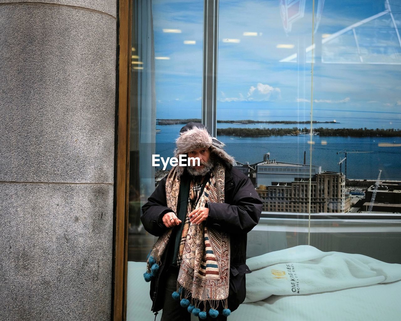 PORTRAIT OF WOMAN STANDING BY WINDOW