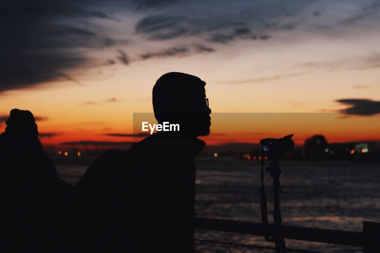 Silhouette of man against cloudy sky at sunset