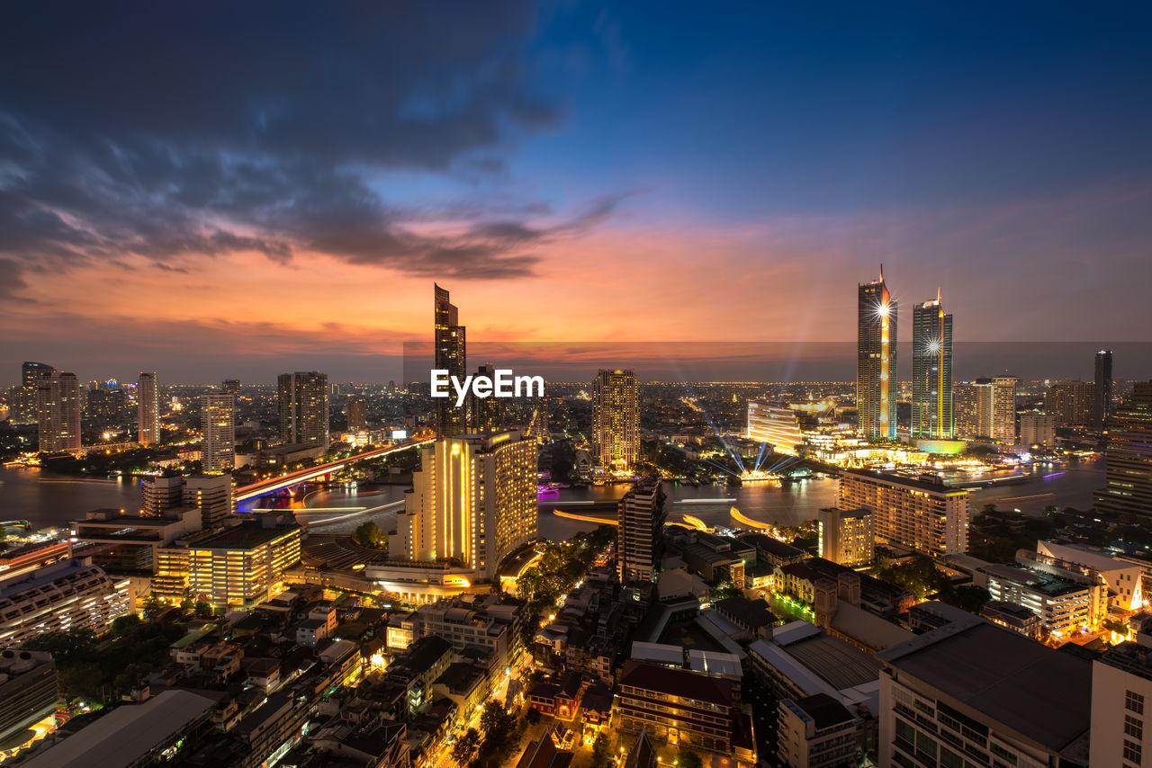 HIGH ANGLE VIEW OF ILLUMINATED BUILDINGS AGAINST SKY