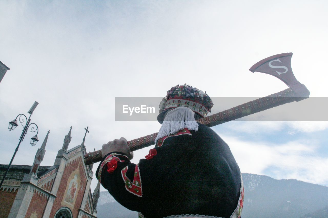 LOW ANGLE VIEW OF MAN PLAYING WITH UMBRELLA AGAINST SKY