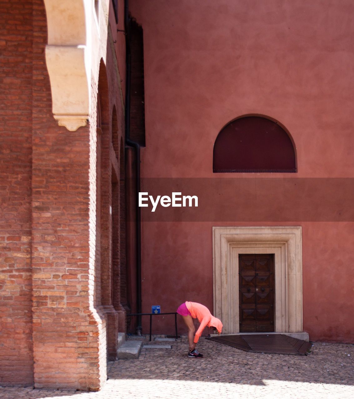 Woman walking by red door