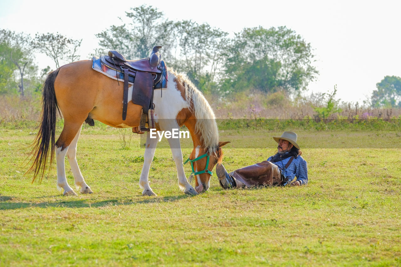 Full length of man with horse on field