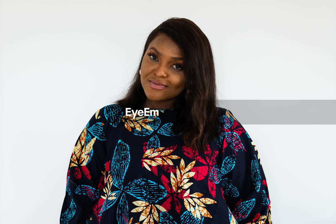 portrait, one person, women, adult, looking at camera, studio shot, indoors, hairstyle, smiling, young adult, photo shoot, white background, long hair, waist up, front view, happiness, clothing, copy space, black hair, sleeve, fashion, pattern, emotion, floral pattern, individuality, standing, female, brown hair, blouse, traditional clothing, headshot, outerwear, lifestyles, cut out