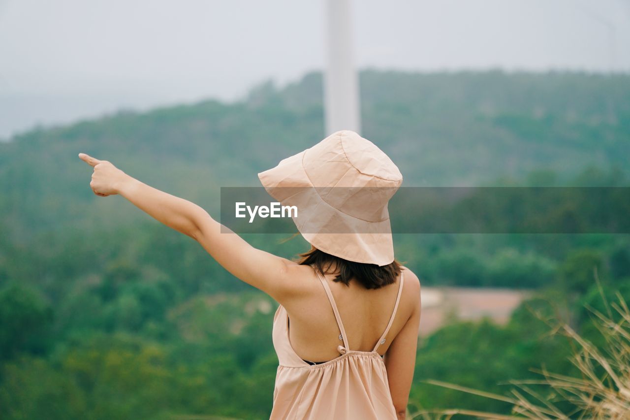 Rear view of woman wearing hat standing outdoors