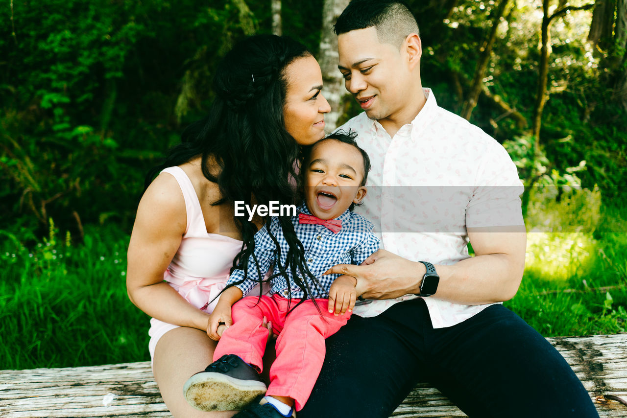 Cropped straight on portrait of a smiling family with a baby boy