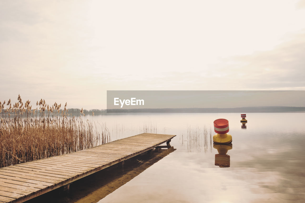 Jetty on lake against sky