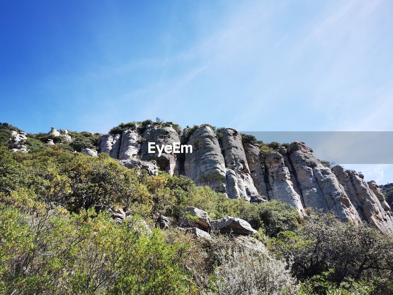 LOW ANGLE VIEW OF ROCK FORMATION ON MOUNTAIN AGAINST SKY