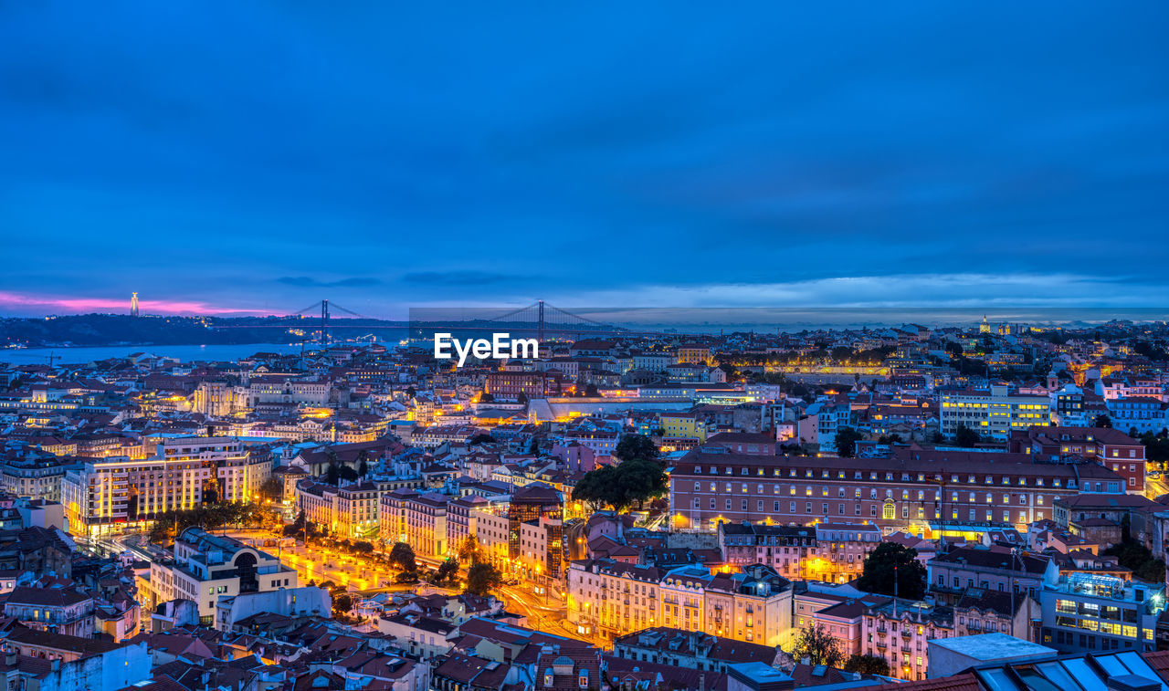 Lisbon in portugal at night with the sanctuary of christ the king and the 25 de abril bridge 