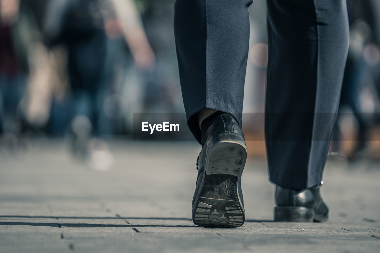 Low section of man walking on footpath