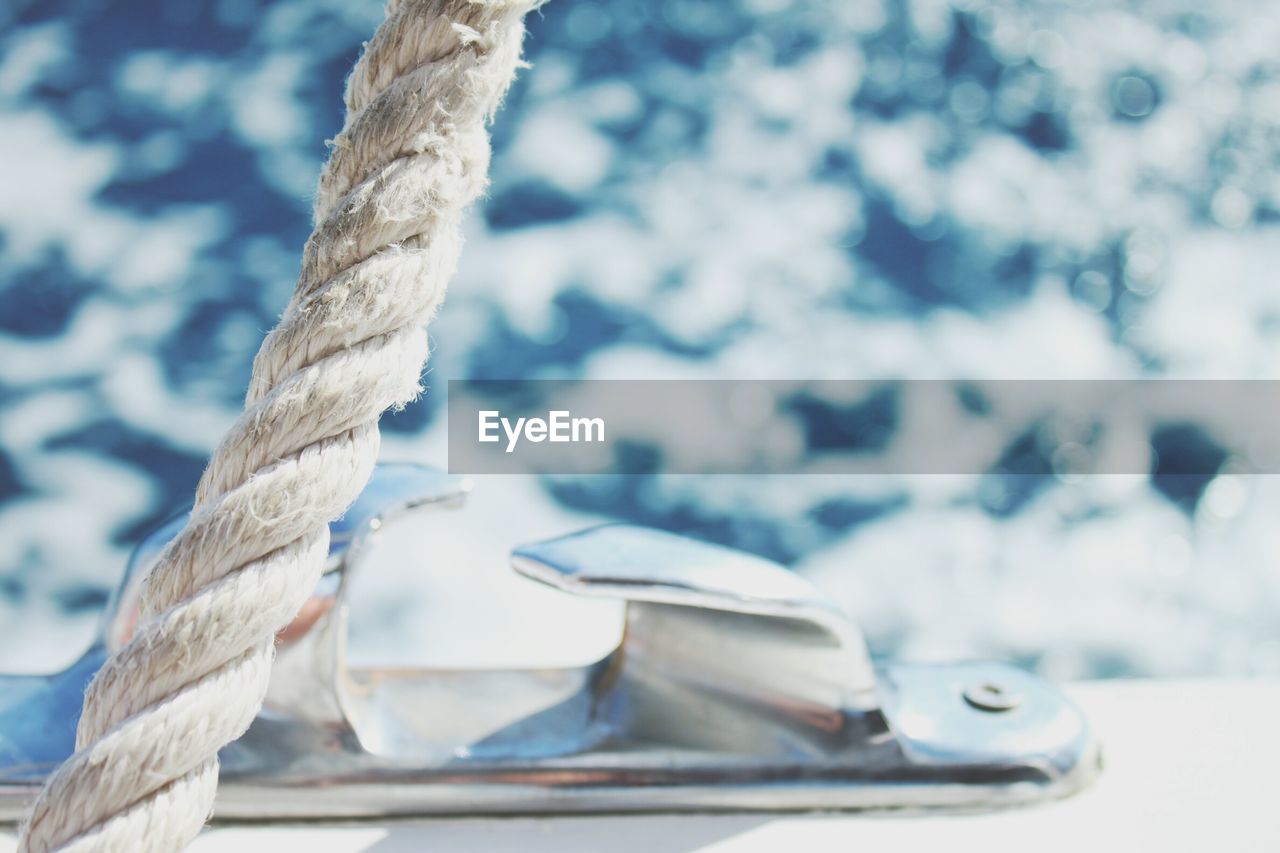 CLOSE-UP OF ROPE TIED UP ON BOAT