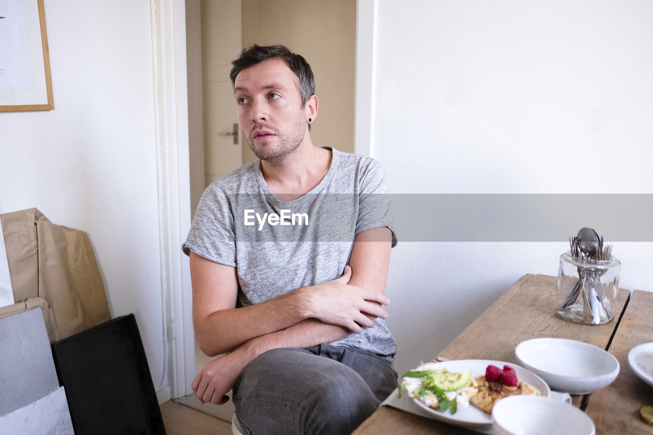 Man sitting by food on table at home