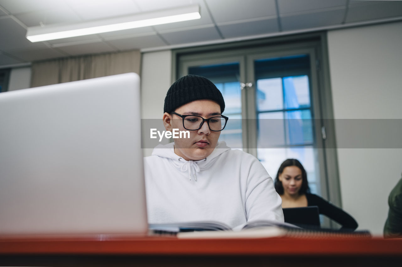 Boys using laptop at desk in school