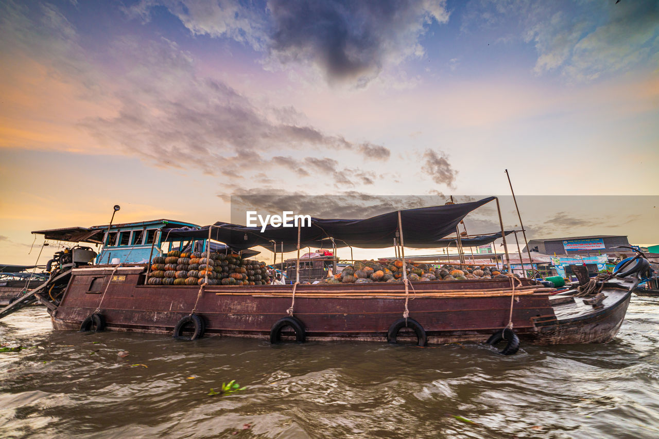 FISHING BOATS MOORED AT SEA AGAINST SKY DURING SUNSET