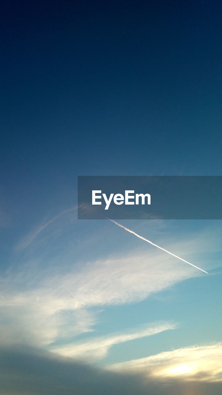 LOW ANGLE VIEW OF VAPOR TRAIL AGAINST BLUE SKY