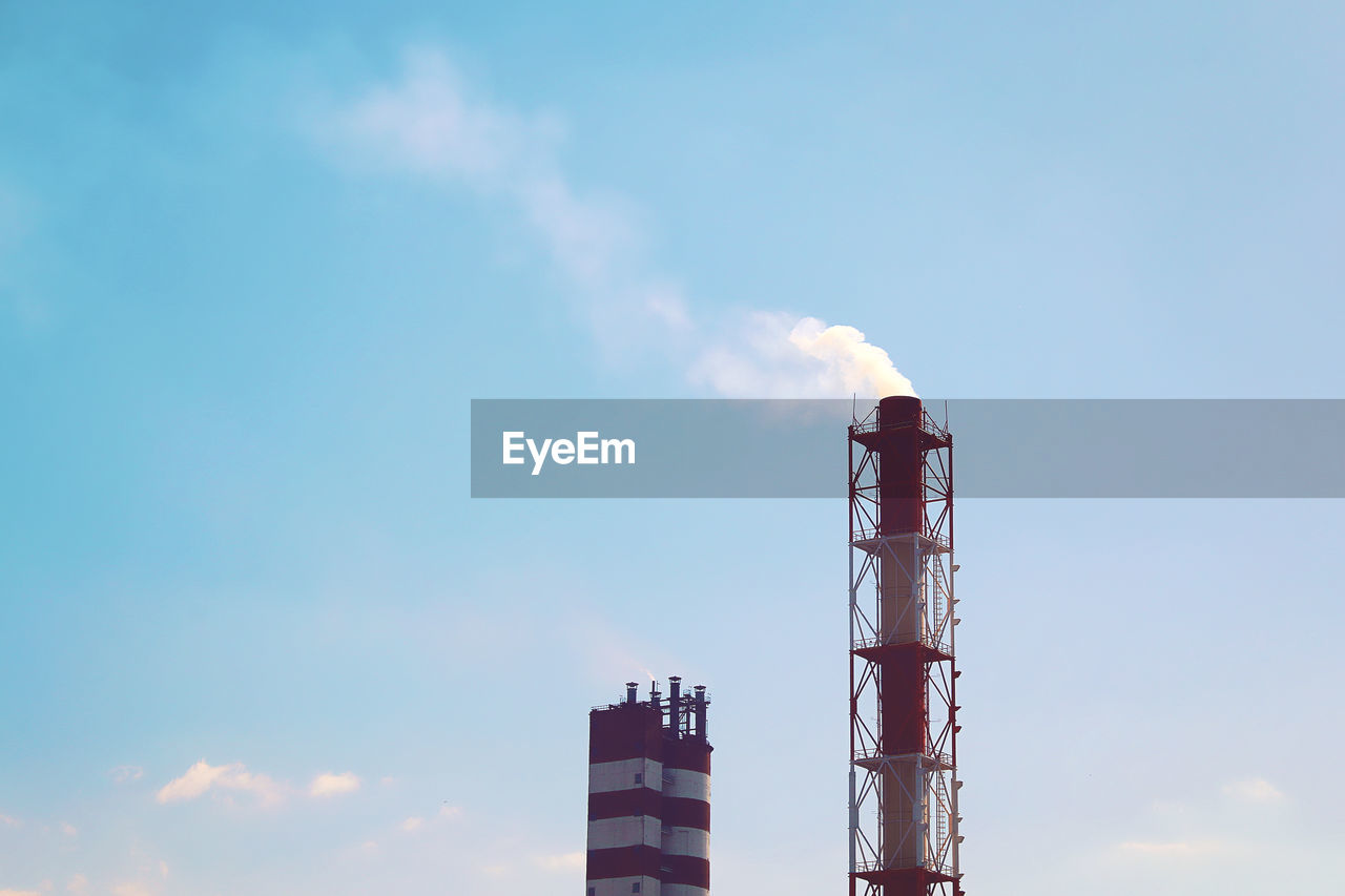 LOW ANGLE VIEW OF SMOKE STACKS AGAINST SKY