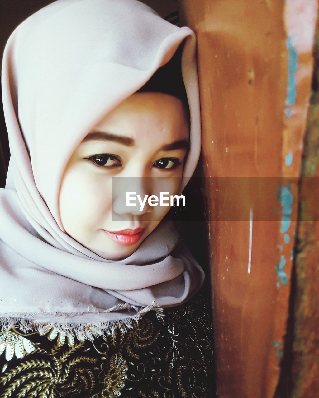 Close-up portrait of woman wearing headscarf indoors