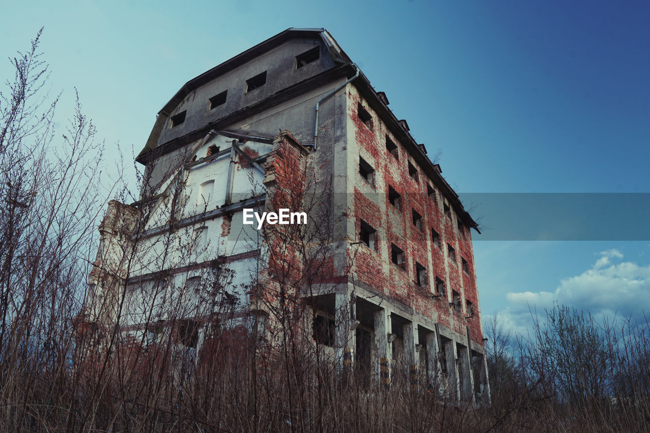 LOW ANGLE VIEW OF DAMAGED BUILDING AGAINST SKY