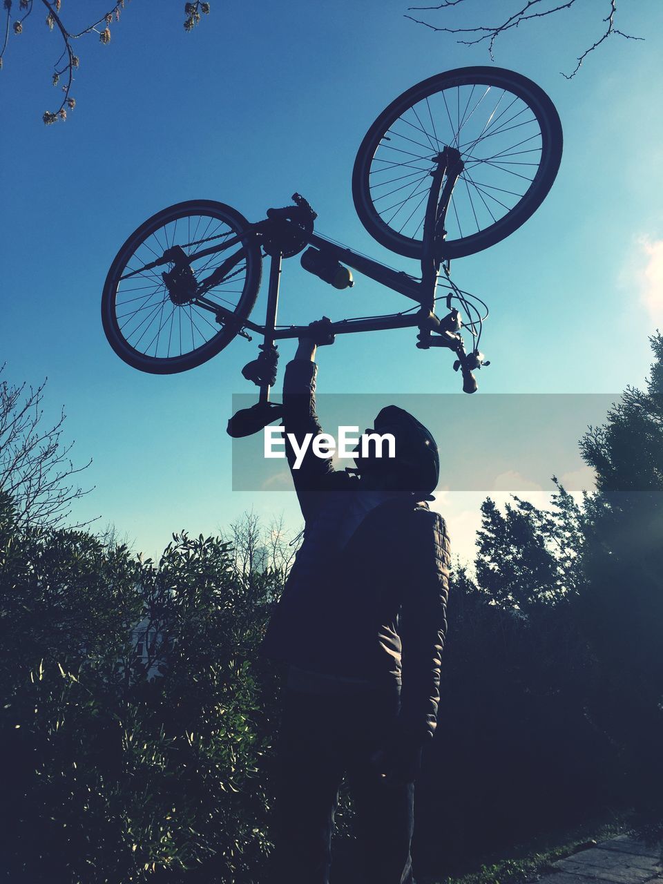 LOW ANGLE VIEW OF SILHOUETTE BOY STANDING AGAINST SKY