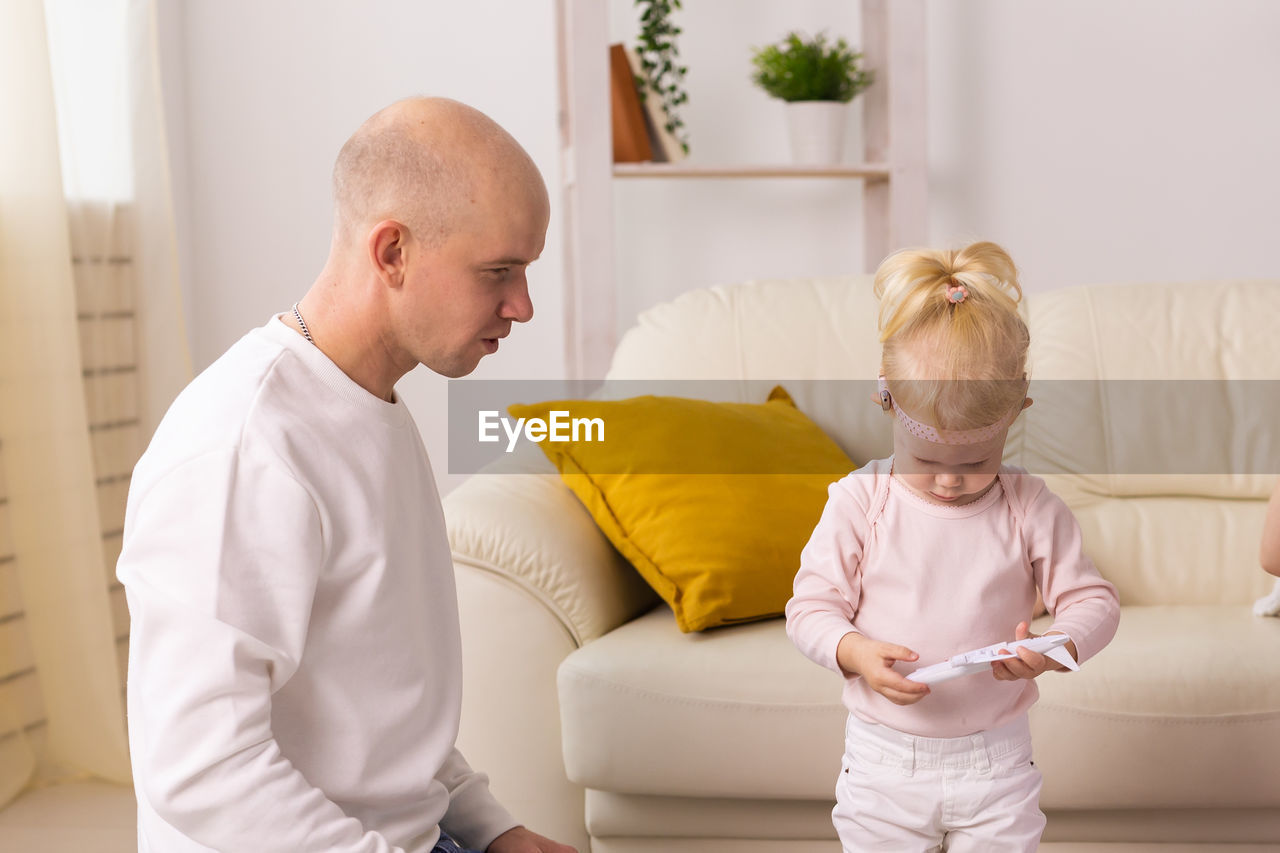 side view of mother and daughter with baby boy at home